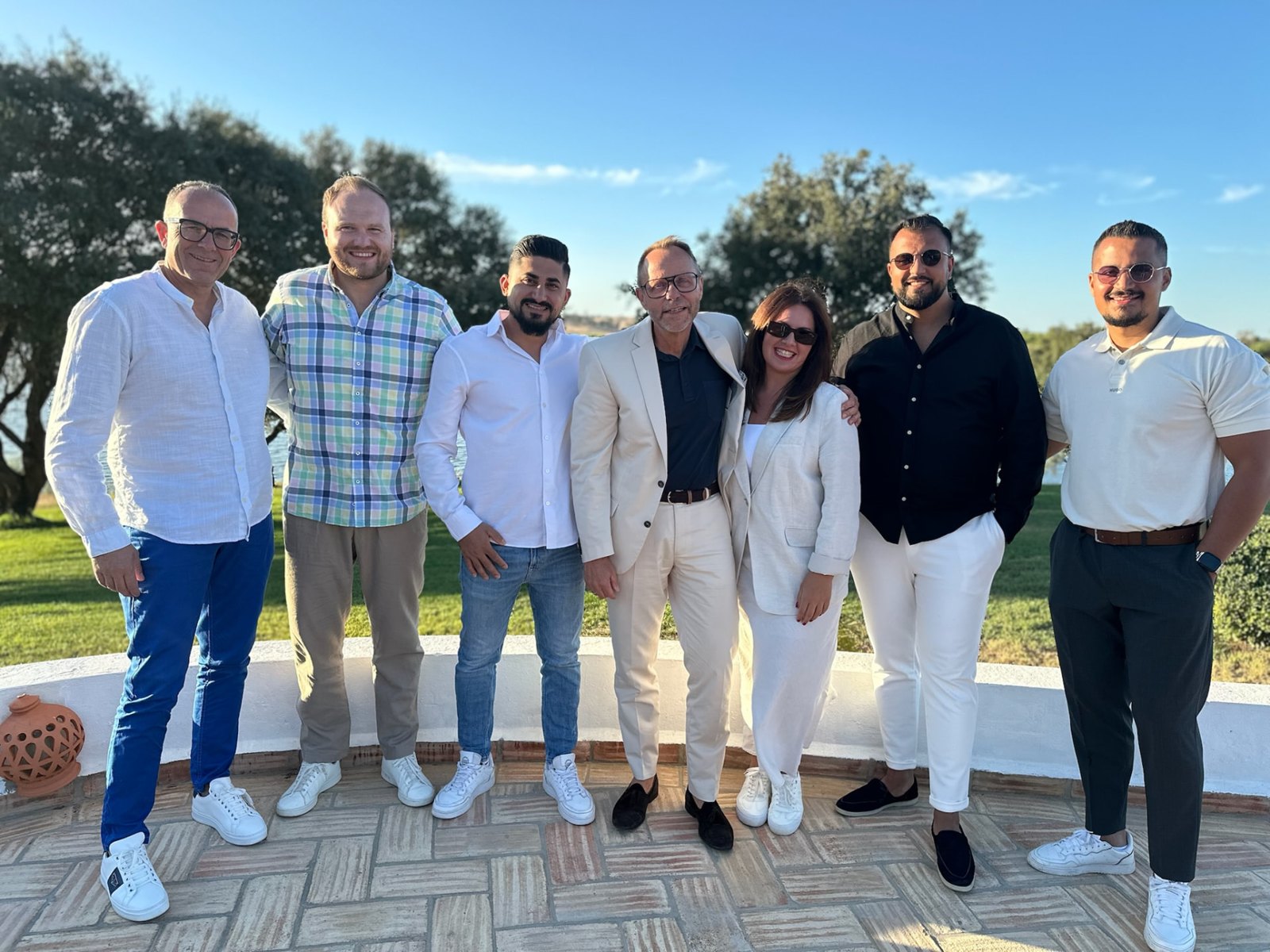 Teamfoto in sommerlicher Kleidung vor blauem Himmel während einer Auslandsreise