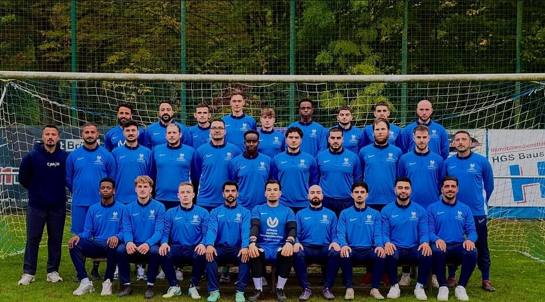 Mannschaftsfoto eines von Sahab Finance gesponserten Fußballteams in blauen Trikots vor dem Tor
