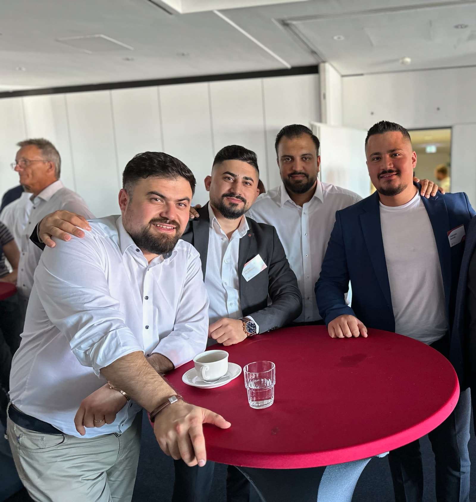 Farshad Sahab mit vier Kollegen an einem Stehtisch bei einer Fachveranstaltung